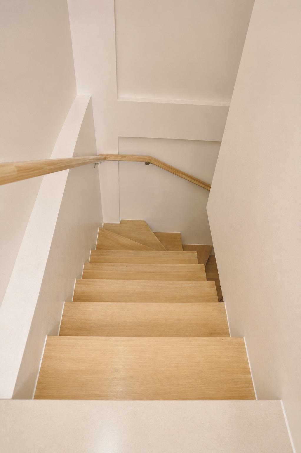 Warm oak staircase with minimalist handrail